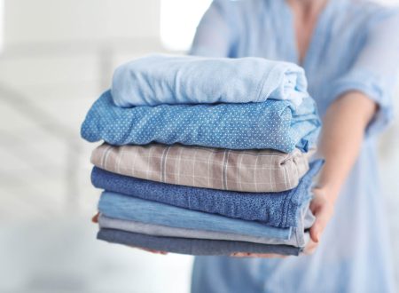 Woman holding stack of clothes, closeup