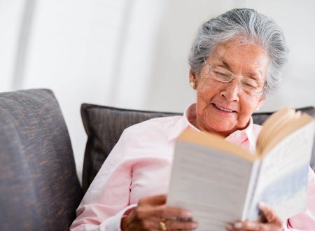 Elder woman reading a book at home and smiling