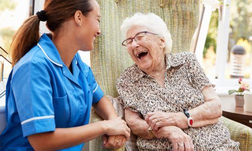 Senior,Woman,Sitting,In,Chair,And,Talking,With,Nurse,In
